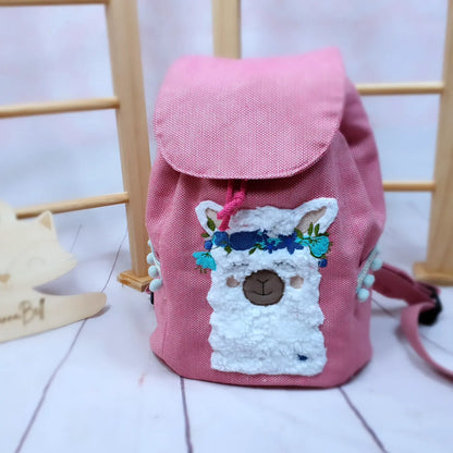 KIndergartenrucksack für Kinder im Alter von 2-6 Jahren. Der Rucksack ist aus einem pinken Strukturcanvas genäht und mit einer BohoLama bestickt. Der Rucksack kann individualisiert werden, ein Wunschname ist inklusive