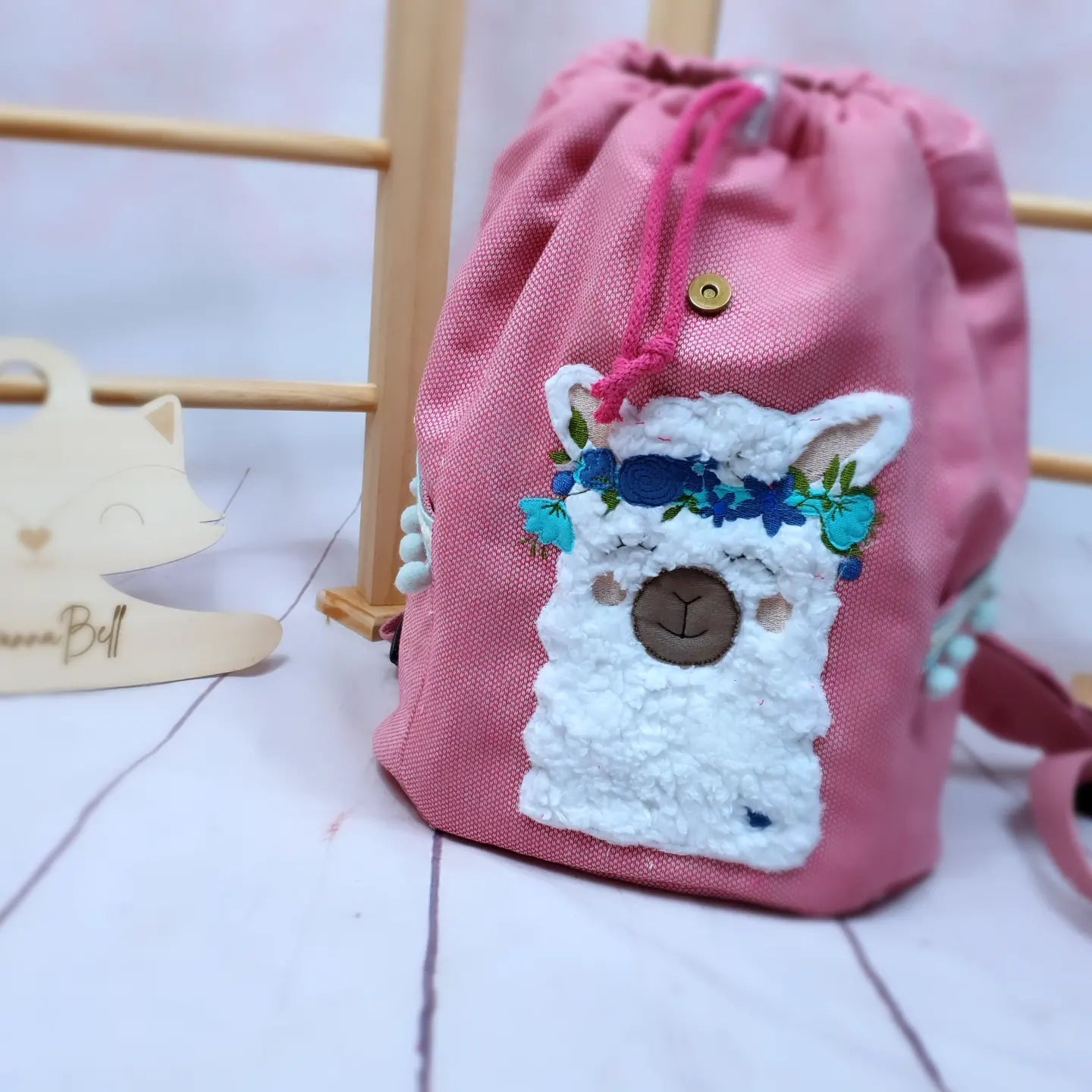 KIndergartenrucksack für Kinder im Alter von 2-6 Jahren. Der Rucksack ist aus einem pinken Strukturcanvas genäht und mit einer BohoLama bestickt. Der Rucksack kann individualisiert werden, ein Wunschname ist inklusive